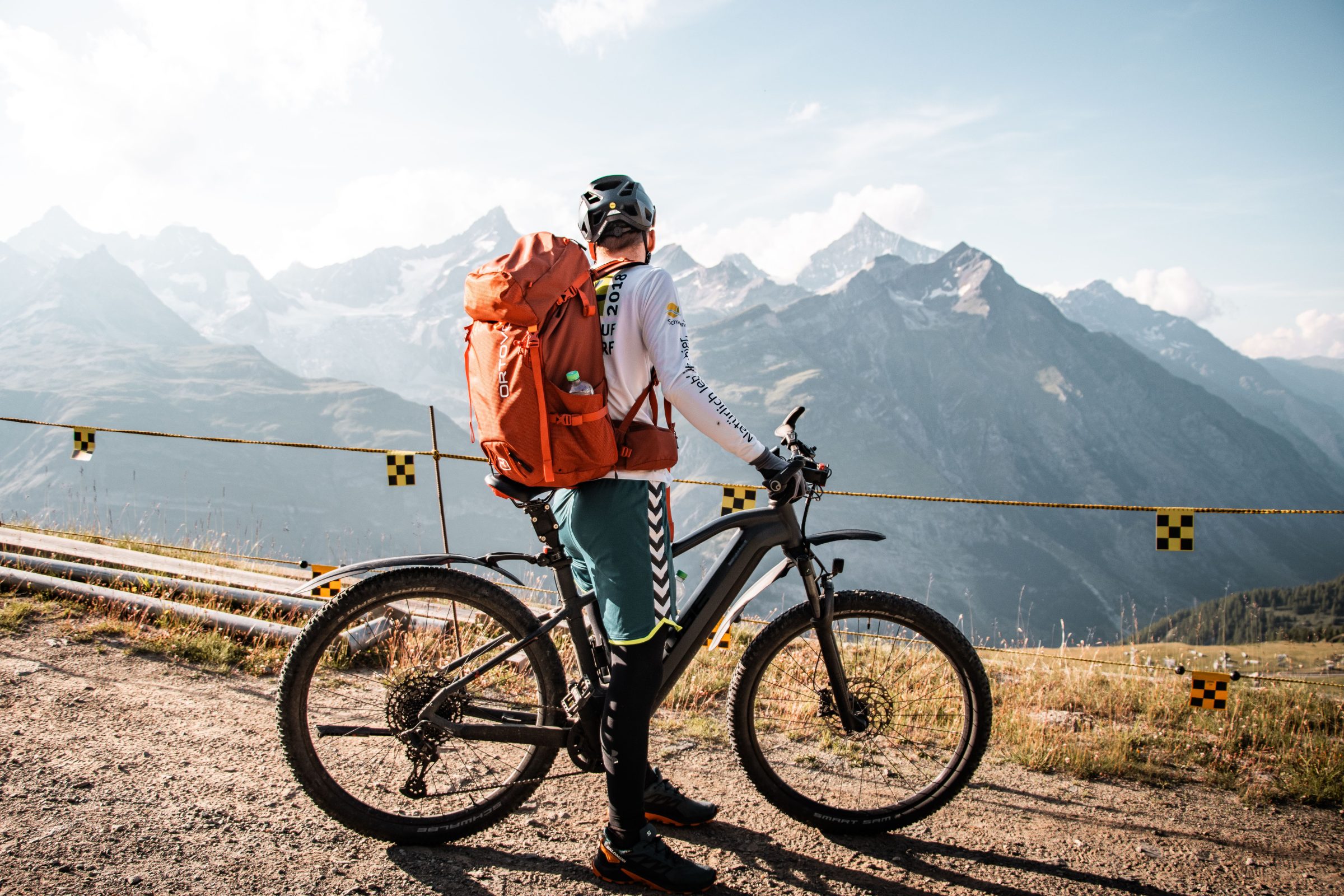 Mountainbiker mit Ausrüstung mit Blick auf die Berge in Saas-Fee, Wallis