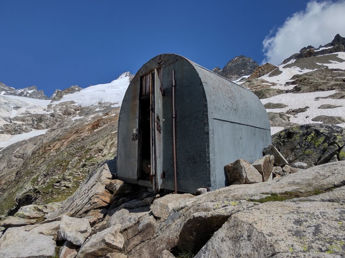 Zelt in üppiger Berglandschaft unter dramatischen Wolken